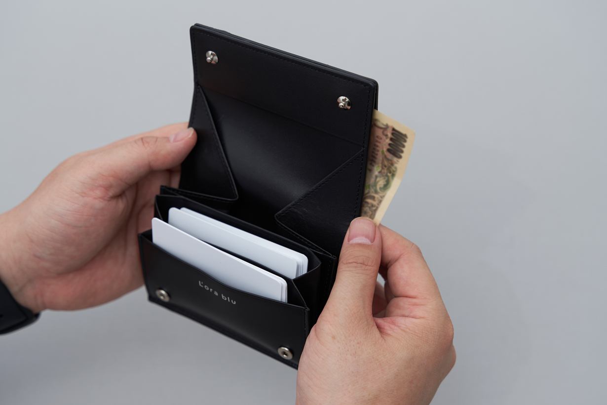 コンパクトな二つ折りながら、大きく開くギャルソン型の小銭入れと、カード・紙幣収納を備えています。